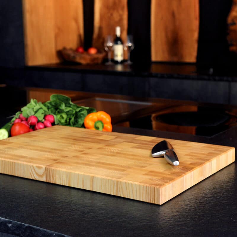 Stirnholz Schneidebrett aus Esche mit hochwertigem messer und Gemüse in einer modernen Küche